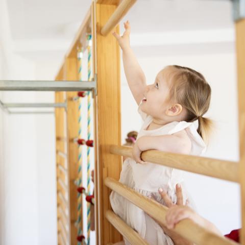 Kindergartenkind klettert im Bewegungsraum der Kita