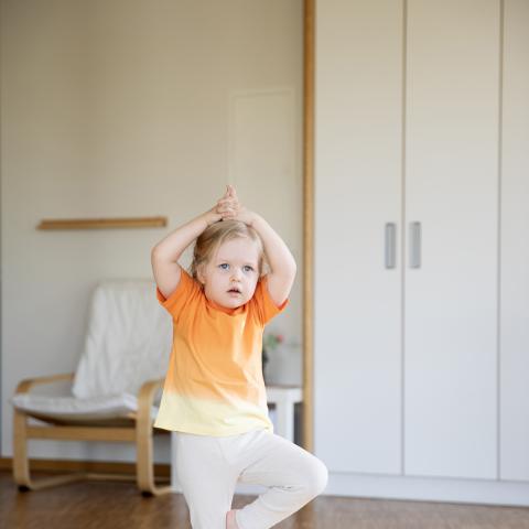 Kind macht Yoga im Bewegungsraum der Kita