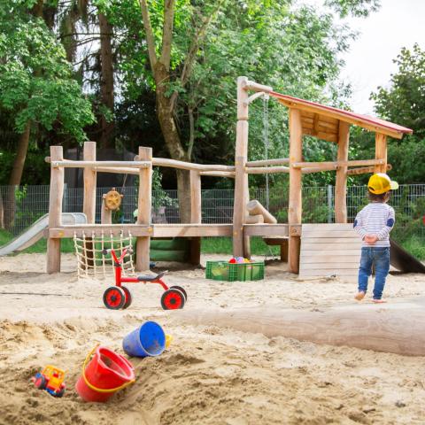 Kindergartenkind spielt im Garten der Kita