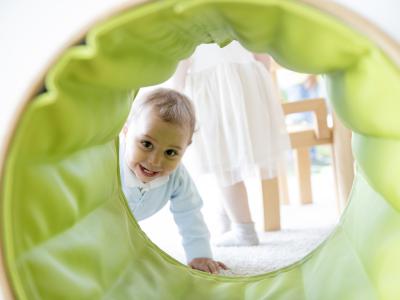 Kinder krabbelt durch einen Tunnel