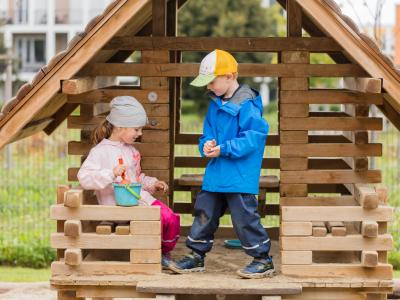 Kindergartenkinder spielen zusammen draußen im Kitagarten