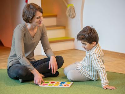 Erzieherin erklärt Kindergartenkind die Farben