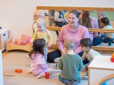 Erzieherin spielt mit Krippenkindern