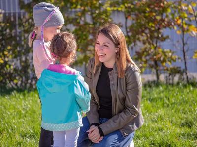 Erzieherin mit zwei Kindern im Grünen