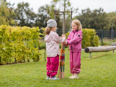  Vorschulkinder spielen im Garten miteinander