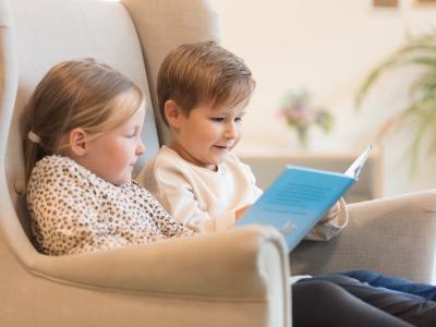 Kindergartenkinder lesen gemeinsam ein Buch in der Kita