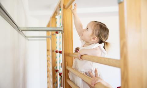 Kindergartenkind klettert im Bewegungsraum der Kita