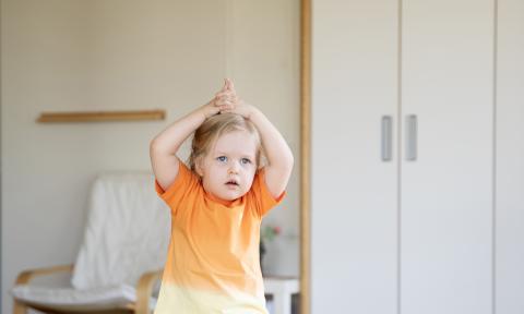 Kind macht Yoga im Bewegungsraum der Kita