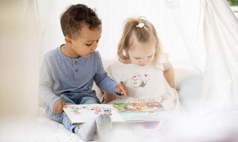 Kindergartenkinder lesen gemeinsam ein Buch