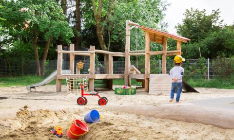 Kindergartenkind spielt im Garten der Kita